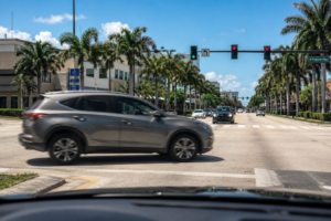 Mid-size SUV making a left turn across an intersection in South Florida with oncoming traffic visible in the distance