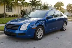 Parked car with fender damage after a hit and run on a Florida street