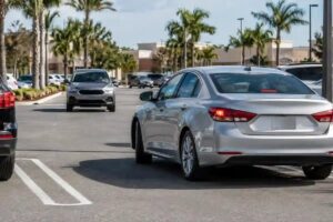 A car backing out of a space toward oncoming traffic in a Florida parking lot, a common parking lot accident scenario